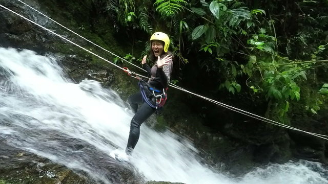 Watch an awe inspiring slow motion footage of a fearless Asiatic girl rappelling down a magnificent waterfall in the enchanting Ecuadorian rainforest.
