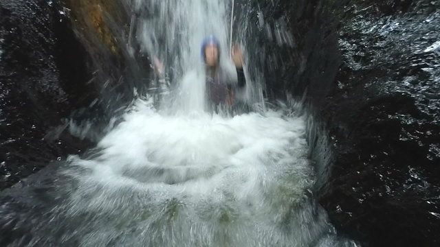 tourist sliding into waterfall and is pulled back into water stream with audio footage slow motion happy run play sport courage tourist water white vacation rock flow nature outdoor waterfall adventu