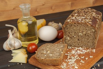 Freshly baked whole wheat bread. Preparing homemade breakfast. Various ingredients for the meal. Sliced bread on cutting board. Advertising on the bakery.

