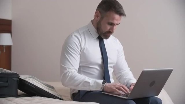 Businessman working on his laptop from a hotel room
