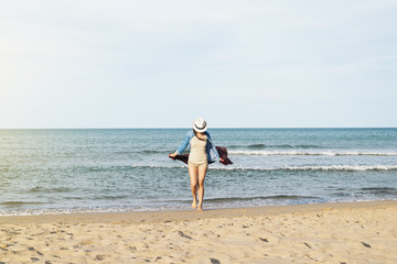 Woman walking away on the idylic beach.