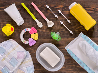 Baby essentials and care on dark wooden table