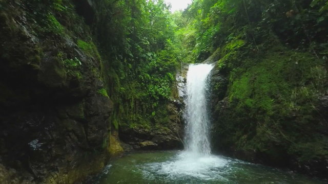 Watch breathtaking slow motion footage as a canyoning instructor slips near a stunning waterfall while rappelling,capturing an unforgettable adventure.