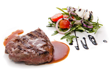 Juicy grilled steak served with a greek salad.
