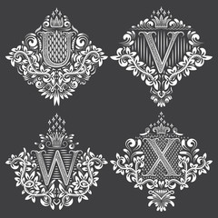 Set of heraldic monograms in coats of arms form. White floral decorative stamps on black. Isolated tattoo labels in vintage baroque style.