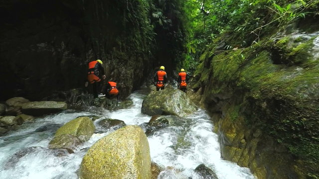 Experience the breathtaking beauty of Llanganates National Park as a group of tourists leisurely explores the stunning Ecuadorian canyon in captivating slow motion footage captured by a static camera.