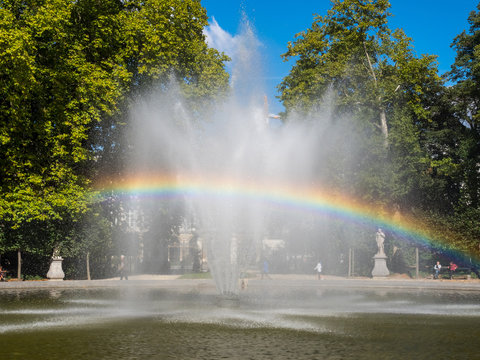 Rainbow from artificial fountain in park