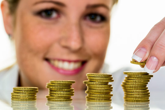 Frau mit Münzstapel beim Geld sparen