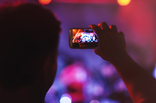 Close up of man with smartphone during a concert