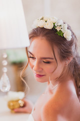 Obraz na płótnie Canvas Beautiful bride blond girl in a wedding dress worn front of the mirror