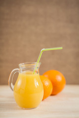 Orange juice in clear jar on a wooden background