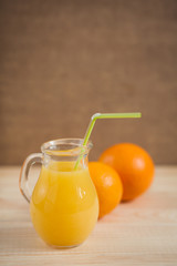 Orange juice in clear jar on a wooden background