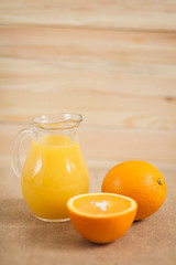 Naklejka na ściany i meble Orange juice in clear jar on a wooden background