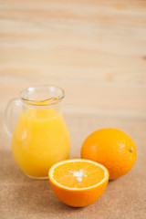 Orange juice in clear jar on a wooden background