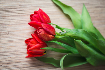 Red tulips on a wooden table