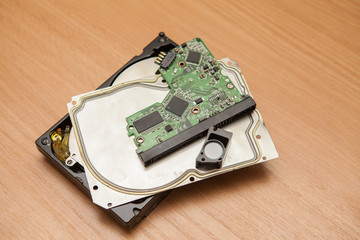 Disassembled hard drive. Details of a pile on a wooden table.