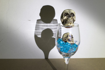 Skulls with blue ice in glass of wine