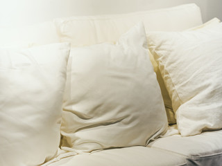 Fototapeta na wymiar White Pillows on Sofa Seat Home Interior decoration