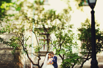 Cute adorable beautiful happy just married couple, stylish bouqu