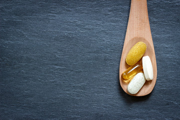 Healthy supplements on wooden spoon - obrazy, fototapety, plakaty