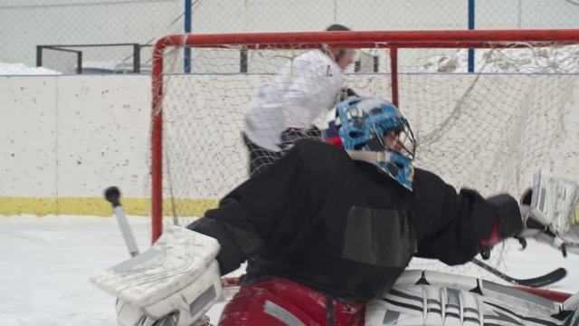 Ice hockey goalie failing to stop a shot and being scored in play at outdoor rink 