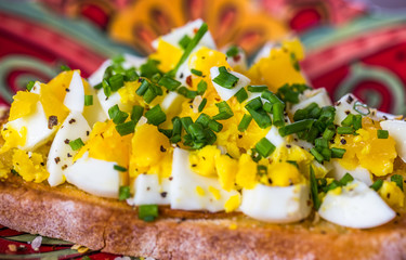 Chopped Eggs on Grilled Toast for Breakfast or Brunch topped with Chives on Colorful Plate, Close-up