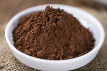 Cocoa powder on wooden background