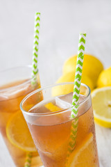 refreshing iced tea with lemon on white wood