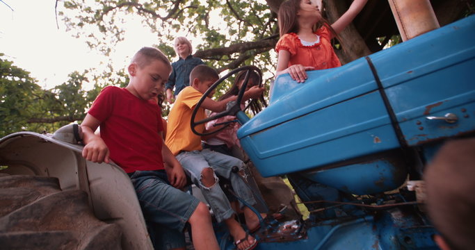 Children playing on an old tractor at the farm
