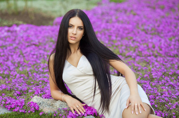 Portrait of a sensual young brunette female on field in sexy dress 