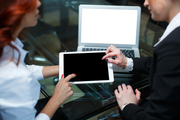 two business girls with tablet computer and laptop at a business meeting
