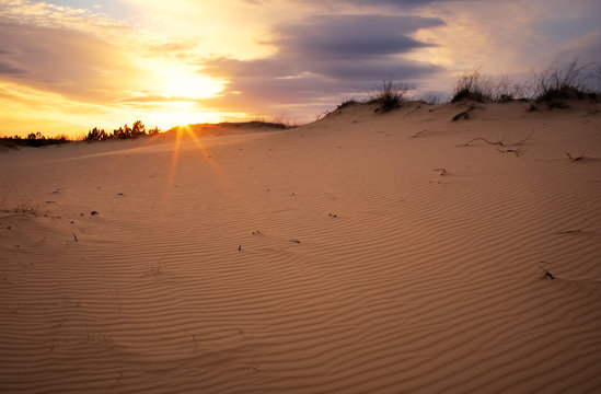 Beautiful Landscape with sunset sky and wavy sand. 