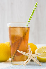 Ice tea with lemon on a beach towel
