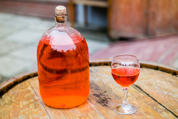 Wine in old bottle on a barrel. - 106480543