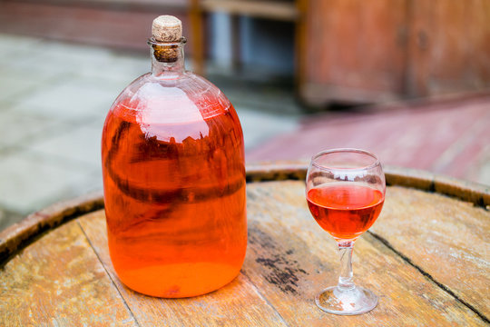 Wine in old bottle on a barrel.