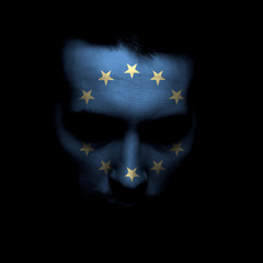 Portrait of a men with the flag of the European union painted on face.