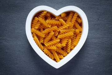Heart shaped bowl filled with gluten free pasta