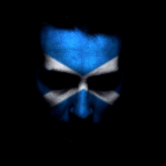 Portrait of a men with the flag of the Scotland painted on face.