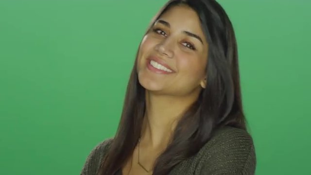 Young woman smiling, on a green screen studio background