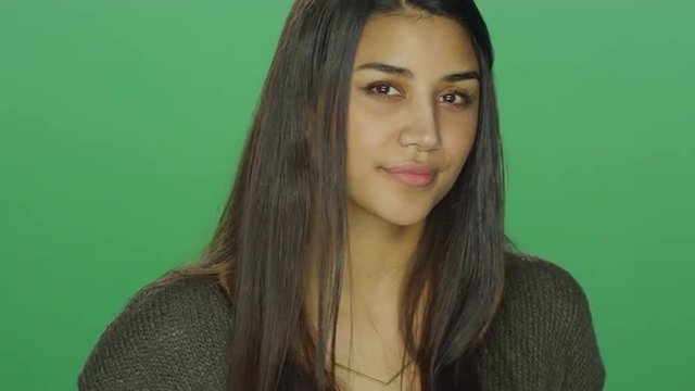 Young woman being flirty, on a green screen studio background
