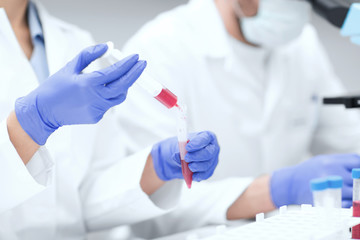 Fototapeta premium close up of scientists hands with test tube in lab