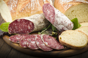 wooden cutting board with salami and bread