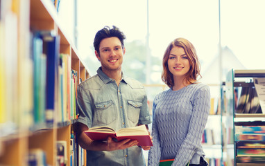 happy student couple with books in library
