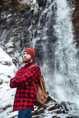 Fototapeta premium Man standing near a waterfall