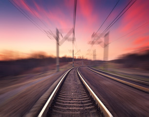 Fototapeta na wymiar Railway station on the background of blue sky at colorful sunset with motion blur effect. Railroad in Ukraine. 