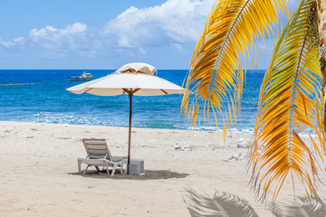 parasol et palmes sur plage de Boucan Canot, île de la Réunion 