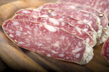 wooden cutting board with salami and bread