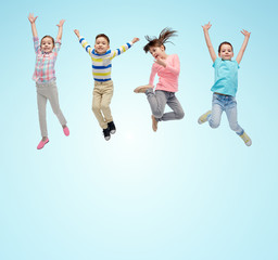 happy little children jumping in air over blue