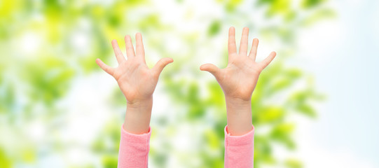 close up of little child hands raised upwards