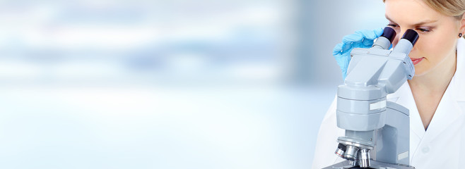 Doctor woman  working with a microscope.